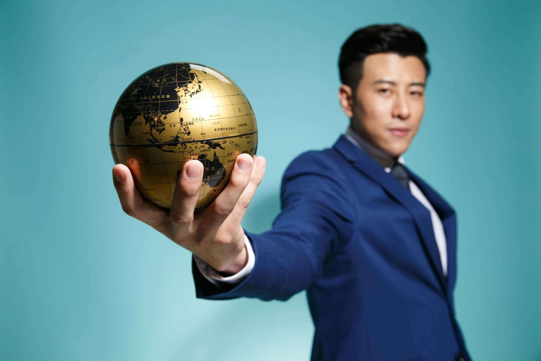 man in blue suit holding a globe